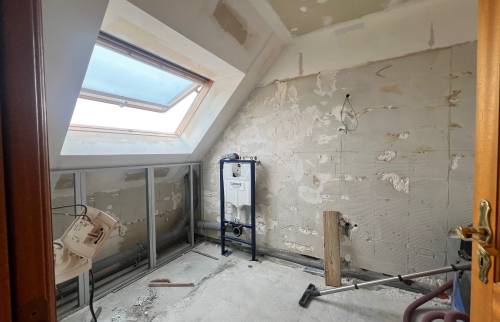 Début des travaux de rénovation d'une salle de bain avec murs déposés, bâti-support WC et préparation de plomberie.