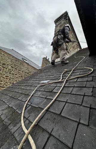 Intervention en toiture avec mise en sécurité par cordage, réalisée par un couvreur spécialisé dans les travaux en hauteur afin d’accéder à la zone d’infiltration.