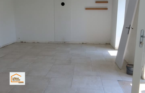 Vue d’ensemble de la nouvelle pièce de vie après la pose du carrelage, avant l’installation de la cuisine. Une rénovation coordonnée par La Maison Des Travaux Quimper dans le Finistère Sud.