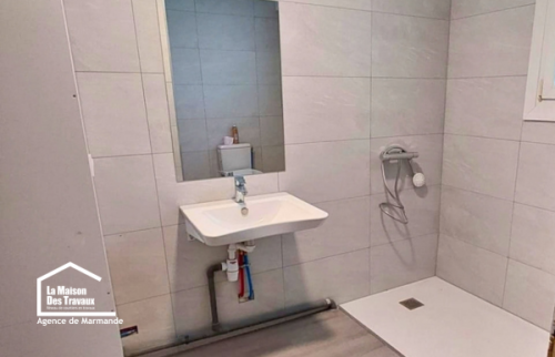 Vue d’ensemble de la salle de bain adaptée à Castillonnès, avec douche accessible, WC et circulation facilitée dans la pièce.