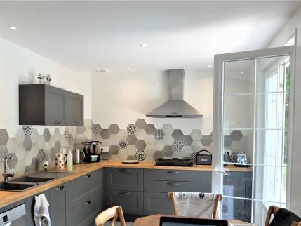 Cuisine rénovée et agrandie dans une villa de l’ouest lyonnais avec crédence carrelée et verrière d’atelier