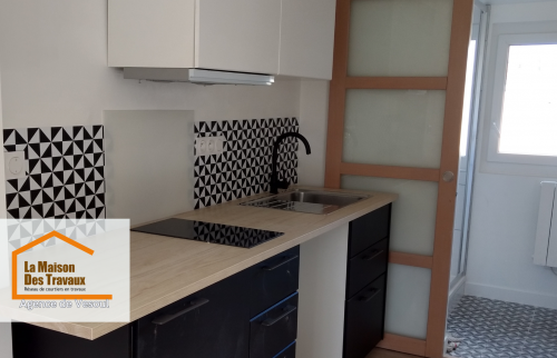 Transformation d’une cuisine à Vesoul : Cuisine rénovée avec un design élégant et fonctionnel. Association de noir, blanc et bois pour un rendu moderne et chaleureux.