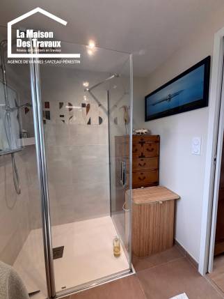 Salle de bain moderne intégrée à une pièce de vie rénovée