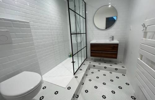 La salle de bain rénovée avec sa paroi de douche