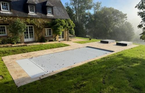 La terrasse de piscine avec le carrelage en travertin