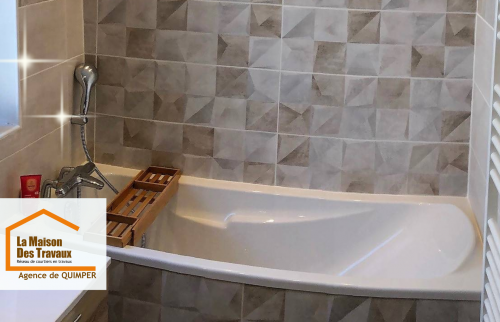 Zoom sur une baignoire élégamment intégrée à un espace détente lumineux et carrelé.