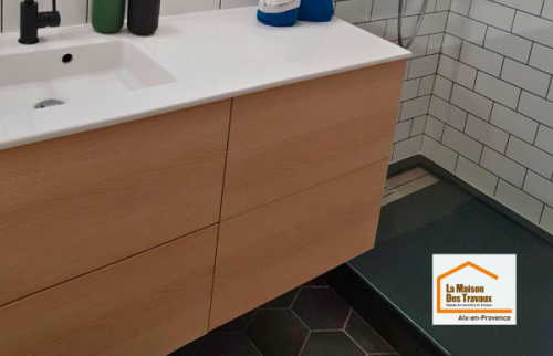 Meuble vasque suspendu en finition bois clair avec miroir rond et éclairage design dans une salle de bain contemporaine rénovée près du Tholonet.