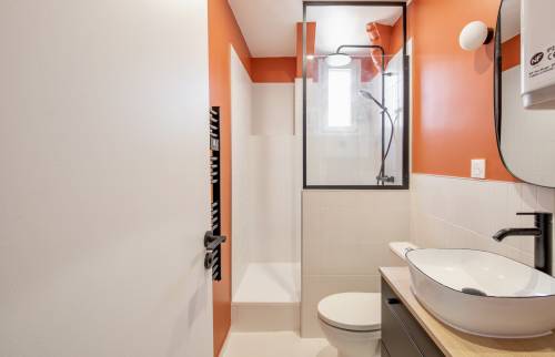 Vue d'ensemble de la salle de bain rénovée avec des carreaux effet marbre.