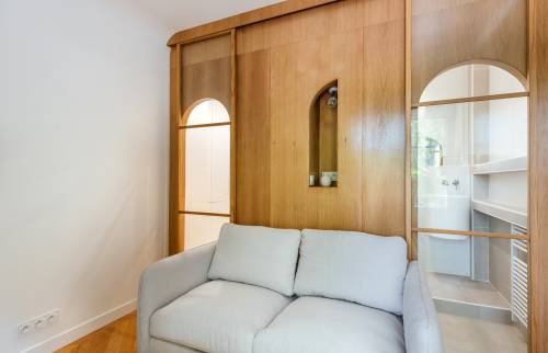 Séparation subtile avec une cloison en bois autour du canapé-lit à Paris 16e