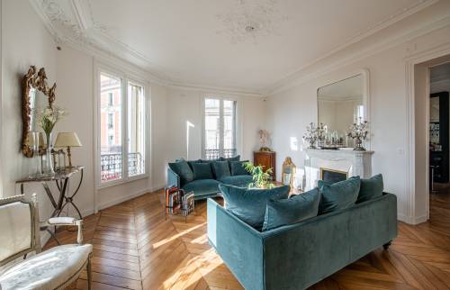 Canapé en velours bleu et table basse en verre : Le cœur moderne d'un salon classique.
