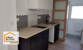 Rénovation complète d’une cuisine pour la location à Marmande : mobilier noir et blanc, plan de travail effet bois et aménagement optimisé par La Maison Des Travaux.