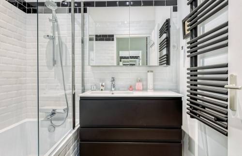 Rénovation d'un appartement ancien dans le coeur de Lyon : salle de bains avec meuble vasque et seche serviette noir mat 