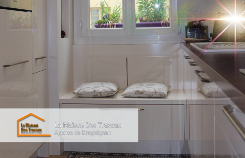 Les placards hauts et le plan de travail en bois apportent chaleur et praticité, parfaitement adaptés aux besoins des propriétaires.