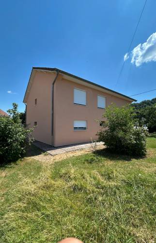 Façade avant rénovée après ravalement complet d’une maison individuelle à Voiron, avec finition soignée et teinte moderne.