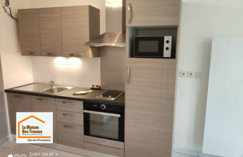 Cuisine moderne installée près de Venelles avec électroménager encastré, nombreux rangements et finitions contemporaines pour améliorer le confort quotidien des occupants.