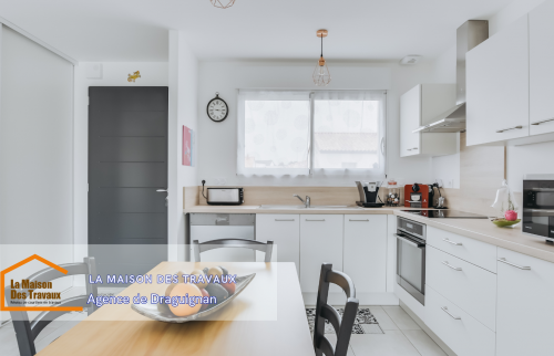 Vue de la cuisine ouverte, équipée de matériaux modernes. 