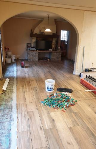 Rénovation du sol du salon autour de la cheminée avec un carrelage effet bois à Renage.