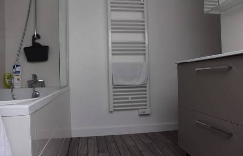 Salle de bain moderne avec sèche-serviette électrique et meuble vasque