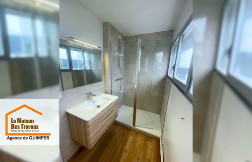 Photo 3 : Vue complète de la salle de bain rénovée à Bénodet, mêlant bois, carrelage moderne et douche spacieuse.
