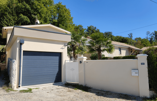 Nouveau garage avec porte sectionnelle gris anthracite et façade rénovée à Saint-Cassien.