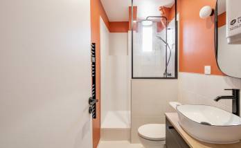 Vue d'ensemble de la salle de bain rénovée avec des carreaux effet marbre.
