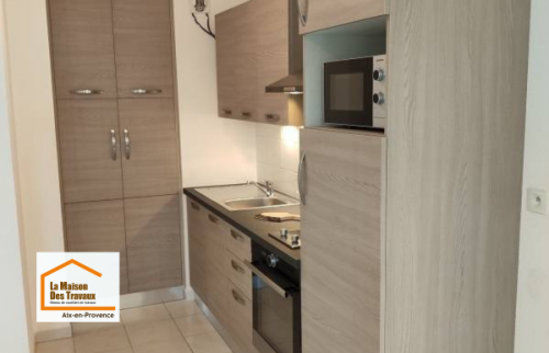 Aménagement d’une cuisine contemporaine avec colonnes de rangement et meubles toute hauteur permettant de maximiser l’espace disponible dans un appartement près de Venelles.