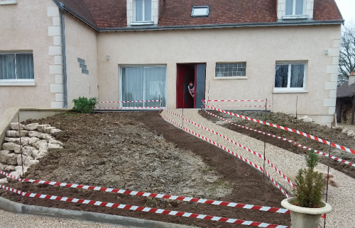 Réaménagement d’une entrée de maison avec allée en jardin en pente