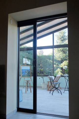 Réalisation d'une Véranda pour création d'un atelier de peinture - Ouest Lyonnais : zoom sur porte coulissante à galandage