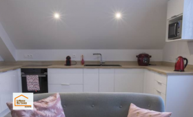 Cuisine moderne réalisée à Quimper avec mobilier blanc, plan de travail effet bois et implantation optimisée. Une rénovation intérieure accompagnée par La Maison Des Travaux Quimper.