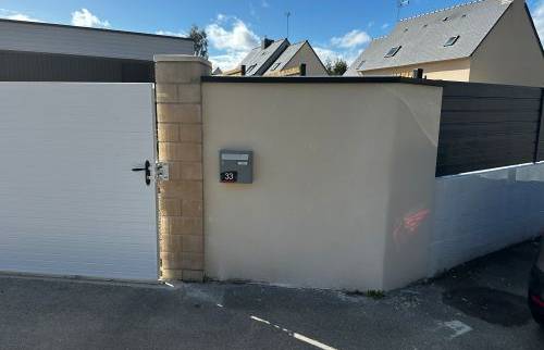 Réalisation d’un enduit sur le muret d’entrée, apportant une finition propre et harmonieuse autour du portail.