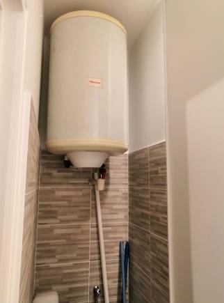 Placard dédié au chauffe-eau électrique et au lave linge dans la salle de bain