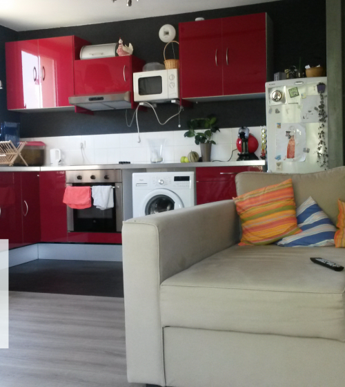 🏡 Cuisine rouge moderne et fonctionnelle, parfaitement intégrée avec électroménagers dans un petit appartement rénové près de Vesoul.