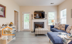 Rénovation salon moderne près de Dreux – Transformation élégante avec sol effet bois, cheminée blanche et canapé bleu cosy. Un intérieur lumineux et chaleureux.