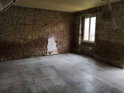 Nouvelle dalle coulée et mur piqué pour supprimer les plâtres collés à la pierre