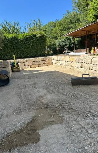 Cour prête à recevoir son revêtement final après terrassement, nivellement et mise en forme complète du terrain.