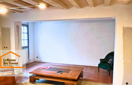 Une vue d’ensemble chaleureuse avec une cheminée restaurée et un intérieur harmonieux. 🏡