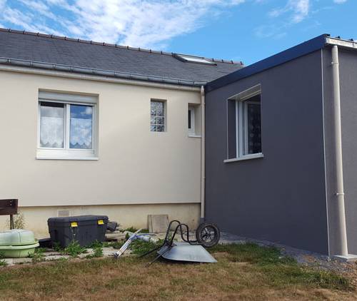 Vue arrière d’une maison à Hyères rénovée avec isolation thermique par l’extérieur, extension grise et façade principale claire.
