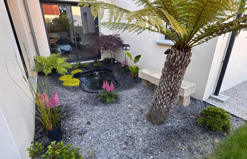 Création d’un espace paysager soigné autour de la maison, mêlant végétal, minéral et point d’eau décoratif.