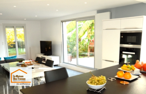Aménagement d'une cuisine contemporaine près de Venelles avec mobilier blanc, plan de travail noir et électroménager intégré, réalisé dans le cadre d'une rénovation intérieure complète.