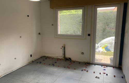 Pose du carrelage sur le sol de la nouvelle cuisine 