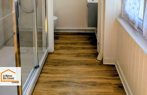 Rénovation sol salle de bain au Guilvinec : PVC effet bois pour une pièce chaleureuse, facile à entretenir et résistante à l’humidité.