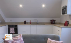 Cuisine moderne réalisée à Quimper avec mobilier blanc, plan de travail effet bois et implantation optimisée. Une rénovation intérieure accompagnée par La Maison Des Travaux Quimper.