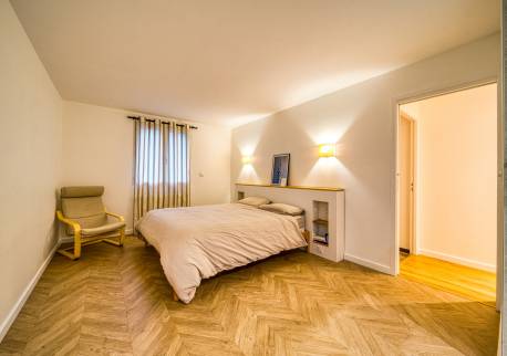 Partie chambre, avec une belle tête de lit et un magnifique parquet posé en chevron