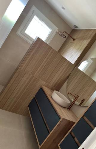 Création d'une douche à l'italienne moderne avec revêtement effet bois et robinetterie finition cuivre.  2