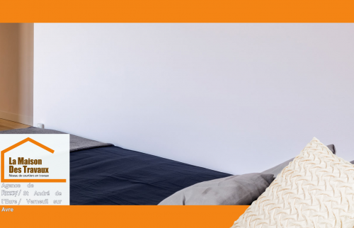 Un mur immaculé et une literie moderne, résultats d’une mise en peinture soignée pour un intérieur apaisant.