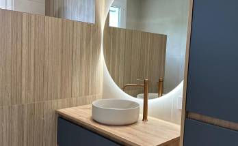 Meuble vasque suspendu sur mesure, miroir rétroéclairé et ambiance chaleureuse pour cette salle de bain rénovée à Voiron.