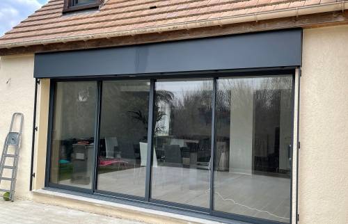 Façade de maison rénovée avec grande baie vitrée moderne après remplacement des fenêtres et porte à Mantes-la-Jolie