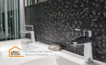 Un meuble sous-vasque suspendu moderne et pratique, avec un mur en carrelage mosaïque pour une touche élégante.