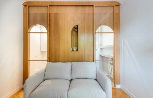 Canapé-lit confortable et élégant dans le salon rénové de Paris 16e