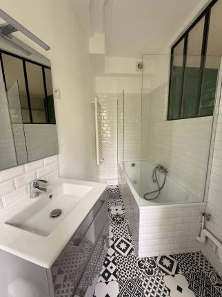 Salle de bain rénovée avec carrelage métro et sol noir et blanc, studio Paris 19